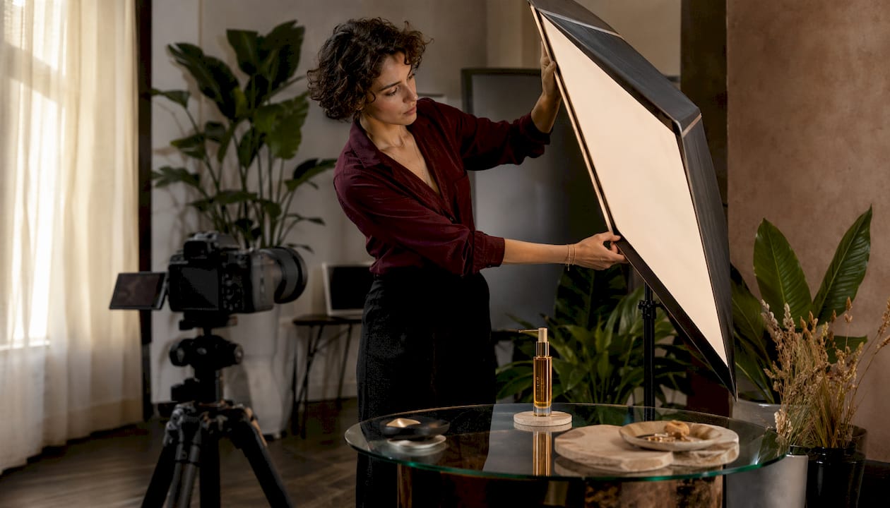 Photographer adjusting lighting for cosmetic product photo